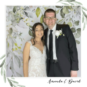 A bride and groom in a photo booth with a garden backdrop